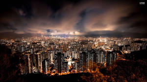 夜晚密集的城市，發光的建築和頭頂上的烏雲。