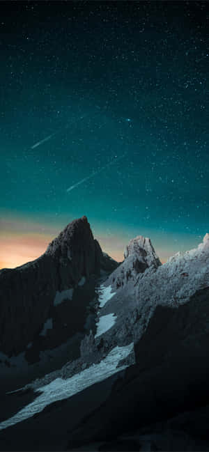 繁星點點的藍綠色天空下，積雪的山峰和一顆流星。 — Tecno Spark 壁紙