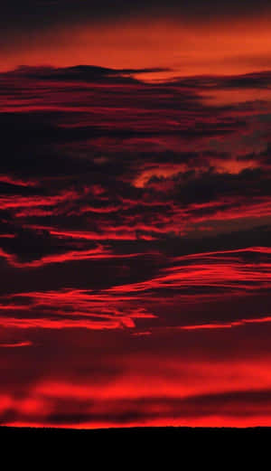 火紅色的雲彩在黑暗地平線之上的黃昏天空中蔓延。 — 美麗的日落動畫 壁紙
