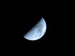 彎月與可見的隕石坑，背景是繁星點點的夜空