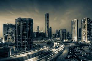 黃昏時分的現代城市天際線，燈火通明的摩天大樓和繁忙的高速公路。 — MacBook Air 13 壁紙