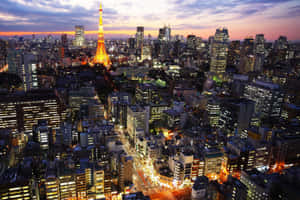 黃昏時分的東京城市景觀，閃耀的東京塔和明亮的建築。 — 東京 壁紙