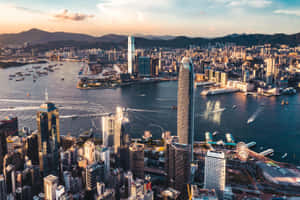 日落時分的香港天際線，摩天大樓和港口船隻 — MacBook Pro 14 壁紙