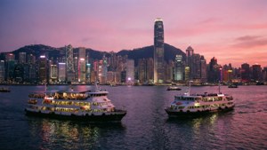 兩艘渡輪在水上，背景為城市天際線於黃昏 — 香港 壁紙