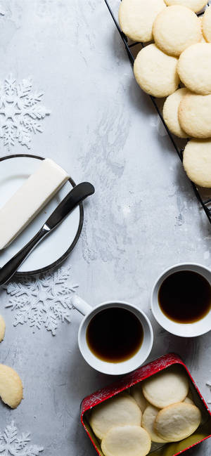 Butter cookies coffee and snowflake decorations on gray surface.