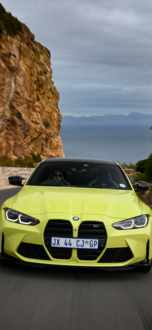 青檸綠色BMW M4在海岸懸崖道路上疾馳，享有海景。
