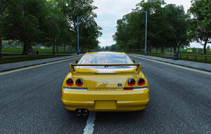 樹蔭路上嘅黃色日產Skyline R34跑車。
