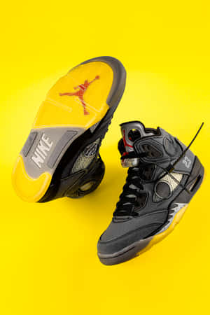 黑黃色Jordan 5運動鞋，黃色背景上帶有紅色標誌。