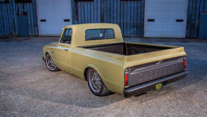 復古黃色雪佛蘭皮卡車停在倉庫門附近的碎石地上。