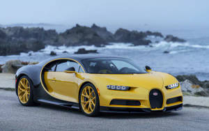 黃黑 Bugatti Chiron 在日落時停泊在海邊。
