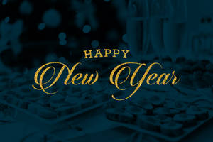 金色「Happy New Year」文字在模糊的香檳和朱古力上方。
