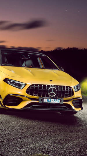 黃色Mercedes-AMG跑車在日落時停泊在碎石路上。