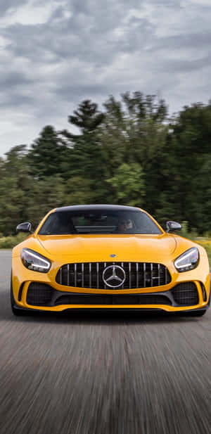 陰天時，黃色 Mercedes-AMG GT 在森林中疾馳。 — 黃色美學 壁紙