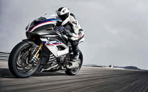 電單車手在賽道上騎著白色、藍色和紅色的BMW HP4 Race比賽。