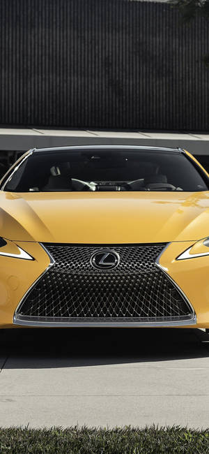黃色Lexus跑車帶有獨特格柵，停在深色牆壁附近。