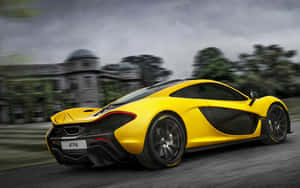 黃色McLaren P1帶動態模糊飛馳經過豪宅。