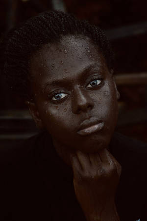 年輕人皮膚上有水珠，藍色眼睛直視觀眾。