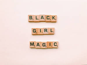 木製 Scrabble 字母磚排列在米色表面上拼出 Black Girl Magic。