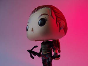黑寡婦Funko Pop人偶在粉紅和紫色燈光下手持弓箭。
