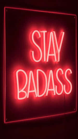 紅色霓虹燈牌，上面「STAY BADASS」字樣明亮發光。