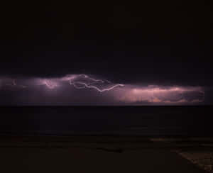紫色閃電劃過黑暗海洋上暴風雨的夜空。 — 暴風 壁紙