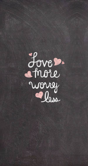 帶有草書文字「Love more worry less」和粉紅色心形的黑板。