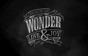 粉筆字在深色黑板上寫著 Season of Wonder Love & Joy。