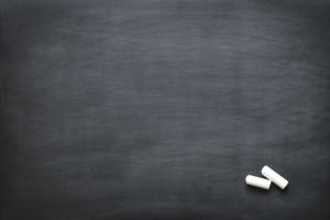 兩支白色粉筆在深灰色黑板表面上。