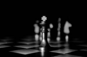 一個國王棋子聚焦在棋盤上，其他棋子模糊地在背景中。