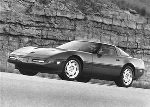 一架經典Corvette跑車停泊在黑白岩石懸崖旁邊。