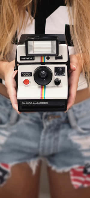 一個人手持Polaroid Land Camera 1000的特寫。