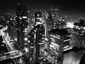 一張模糊的黑白照片，拍攝夜晚的城市，帶有發光的燈光。 — 黑暗森林 壁紙