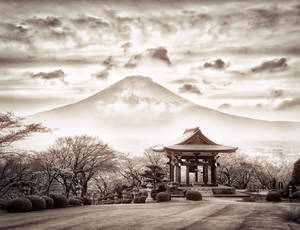 富士山前的傳統日本亭閣，伴隨光禿樹木和陰雲天空。