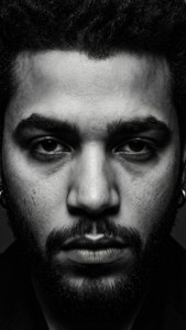 黑白特寫肖像，一名留鬍鬚的男子眼神銳利。 — The Weeknd 壁紙