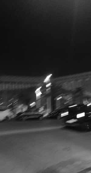 夜間街景，汽車和燈光因運動而模糊。