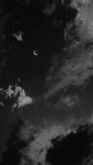 新月和星星在寧靜的夜空中，從飄動的雲層中探出頭來。