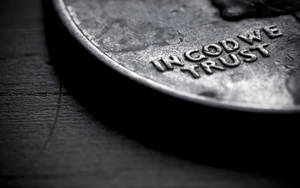 一枚磨損嘅美國一分錢硬幣特寫，上面有「IN GOD WE TRUST」，放喺深色木頭上。