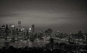 紐約天際線的夜晚黑白景觀，明亮的建築物和橋樑。