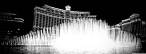 Bellagio 噴泉在夜間亮燈，背景為酒店