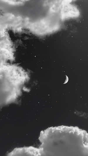 新月和星星在黑暗的夜空中透過雲層窺視。