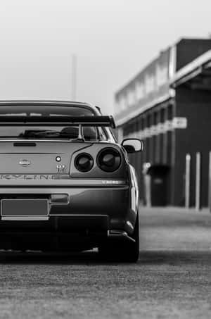 一輛日產Skyline GT-R V-SPEC停泊在車庫前的背面視圖。