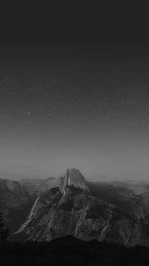 Half Dome 山在星空夜空下的剪影，黑白風格。