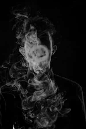 黑白肖像中，旋轉的煙霧遮蓋了一個人的臉部。