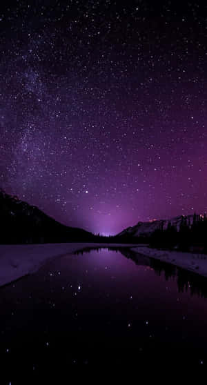 繁星點點的紫色夜空倒映在平靜的湖面上，四周環繞著積雪的山巒。