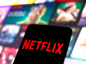 手機特寫顯示Netflix標誌，背景是模糊的串流內容。