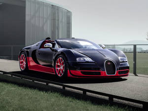 黑色和紅色的Bugatti Veyron超級跑車停泊在現代建築附近的戶外。
