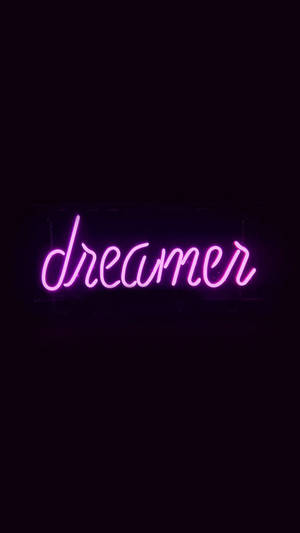 在黑暗房間中，一個寫著 dreamer 的粉紅色霓虹燈牌。 — 黑紫 壁紙