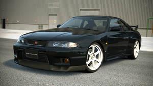 黑色日產Skyline R34跑車配白色輪圈停在瀝青路面。