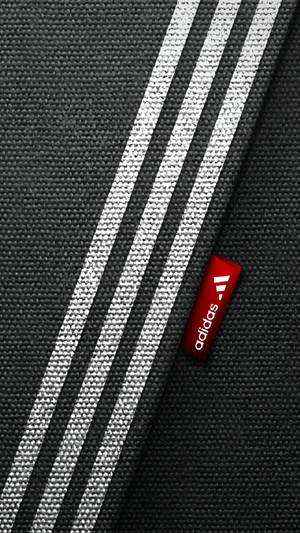 帶有白色條紋和紅色品牌標籤的黑色Adidas布料 — 三星 Galaxy S20 壁紙