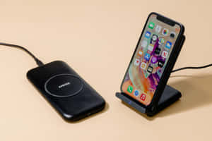 米色表面支架上的黑色Anker無線充電器和iPhone。 — MacBook Air 13 壁紙
